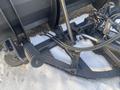 A black 2000 plow with a 12-foot attachment featuring a spring-loaded mechanism and chains for stability and control