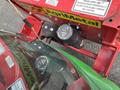 A 2014 John Deere 1585 Terrain Cut mower featuring control levers and warning labels in the foreground