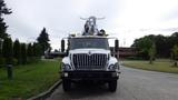 Front view of a 2012 International 7400 truck equipped with an aerial lift and multiple lights on the top