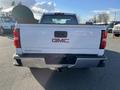 A white 2018 GMC Sierra 1500 viewed from the rear showing the tailgate with the GMC logo and Sierra lettering