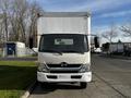 Front view of a white 2015 Hino 195 box truck with large side mirrors and a blank front grille