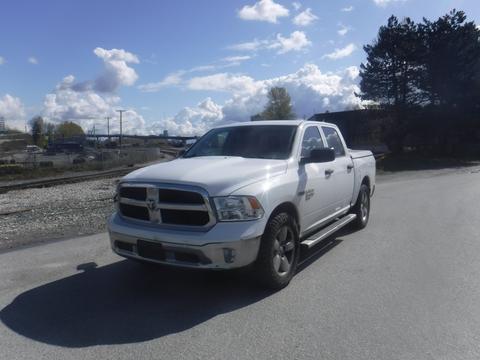 A white 2019 RAM 1500 Classic Eco Diesel pickup truck with a silver grille and tinted windows parked on a road