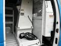 A 2009 Ford Econoline with an open cargo area featuring white shelving and a metal divider on one side