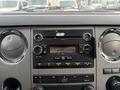 The interior dashboard of a 2013 Ford F-350 SD featuring a radio display with knobs for volume and settings