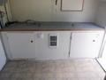 Interior view of a 2004 Royal 18 Foot Office Trailer featuring a countertop with cabinets below and a wall-mounted heating unit