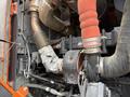 A close-up view of the engine components of a 2018 Doosan DL300 -5 including pipes hoses and heat shields