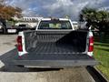 A 2017 GMC Sierra 1500 with an open truck bed showcasing a black lining and the GMC logo on the tailgate