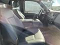 Interior of a 2013 Ford F-250 SD featuring two front seats with a console in between and a steering wheel visible