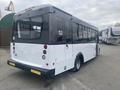 A 2018 Chevrolet Express bus with a white body and black accents visible from the rear侧面. The vehicle has large windows and round taillights