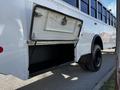 A 2022 Blue Bird Vision school bus with a side storage compartment opened revealing a black interior and sturdy support cables