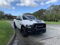 A 2021 RAM 1500 pickup truck with a white exterior and black accents parked on a paved surface