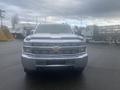 A 2015 Chevrolet Silverado 3500HD with a chrome front grille and large headlights facing directly forward