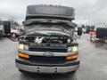 A 2017 Chevrolet Express van with its hood raised showcasing the engine compartment