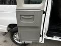 A close-up of the passenger side door of a 2011 Ford Econoline featuring a gray handle and a textured panel design