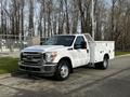 White 2016 Ford F-350 SD with a utility bed and side compartments parked on a paved surface