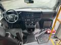 Interior view of a 2018 Chevrolet Express showing the driver's seat dashboard control panel and center console with cup holders