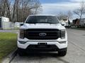 A 2021 Ford F-150 facing forward with a white exterior and black grille showcasing its distinctive design and LED headlights