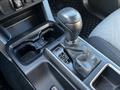 The image shows the gear shift and console of a 2021 Toyota Tacoma with a black gear knob and leather boot