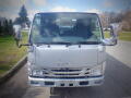 Front view of a 2008 Isuzu Elf with large side mirrors and a prominent grille displaying the Isuzu logo