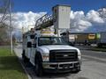 A white 2008 Ford F-550 bucket truck with a raised articulating boom and a large bucket for elevated access
