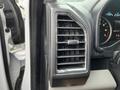 Close-up of the air conditioning vent in a 2016 Ford F-150 with a metallic grille and a manual adjustment lever