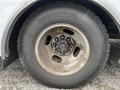 A close-up of a 2017 Chevrolet Express wheel showing the tire tread and wheel rim with visible dirt and wear on the surface