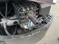 Close-up of a 2024 AGT Industrial Green QH13R Mini Excavator engine showing a black metal housing and various mechanical components