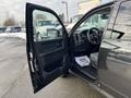 A 2015 RAM 1500 with an open driver side door displaying the interior features and controls