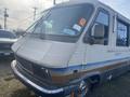 1987 Chevrolet Fleetwood Pace Arrow motorhome with a distinctive front design featuring rectangular headlights and a blue stripe along the side