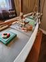 1974 model sailboat with detailed deck featuring green control boxes life rings and a small barrel on a tabletop