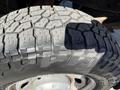 Close-up of a 2013 Ford F-250 SD tire showing its rugged tread pattern and brand name on the sidewall