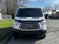 A 2017 Ford Transit van in a front view with a silver and black exterior showcasing the Ford logo and a large windshield