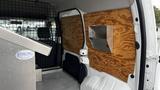 A 2012 Ford Transit with wooden paneling on the interior walls and a metal box securely mounted to the side