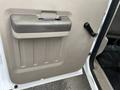 Interior door handle and panel of a 2010 Ford F-250 SD with a textured gray surface and a mechanical window crank