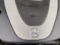 Close-up of a 2007 Mercedes-Benz E-Class engine cover featuring a prominent V6 badge and the iconic Mercedes-Benz star emblem