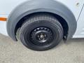 Close-up of a 2013 Ford Transit Connect's front wheel featuring a black steel rim and a tire with visible tread patterns