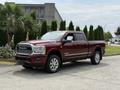 A red 2024 RAM 3500 pickup truck with chrome accents and large wheels parked in a driveway