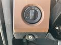 A control dial for adjusting the headlights in a 2022 Freightliner Cascadia with a textured brown surround and a key slot below it
