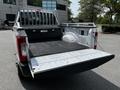A 2017 Ford F-250 SD with an open truck bed showing a rubber floor liner and a tailgate that is lowered
