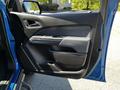 A blue 2021 Chevrolet Colorado driver's side door interior showing the handle and window controls