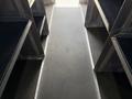 Interior view of a 2016 Ford Transit with a clear walkway between metal benches for passengers