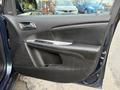 The interior door panel of a 2013 Dodge Journey featuring a black finish with silver trim and control buttons for windows and locks