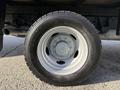 A close-up view of a wheel and tire from a 2019 Ford F-550 showcasing a white steel rim and a rugged black tire with visible tread pattern