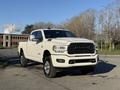 A white 2023 RAM 3500 truck parked with a prominent front grille and chrome accents showcasing its robust design and elevated stance