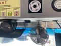 A 2012 Ford Econoline interior featuring a metal ceiling with a small fan attached and a speaker mounted on the side