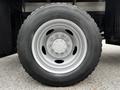 A close-up of a 2011 Ford F-550 wheel featuring a silver rim with multiple bolts and a robust black tire with deep treads