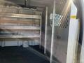Interior of a 2016 GMC Savana cargo van featuring metal shelves and a partitioned area for separation