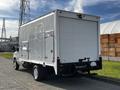 A 2013 Ford Econoline box truck with a white exterior and rear loading door parked on a concrete surface