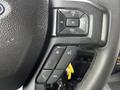 Close-up of the steering wheel controls in a 2017 Ford F-550 featuring buttons for volume and phone functions