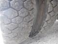 Close-up of a worn tire on a 2002 International 4700 showing deep tread patterns and signs of wear and tear